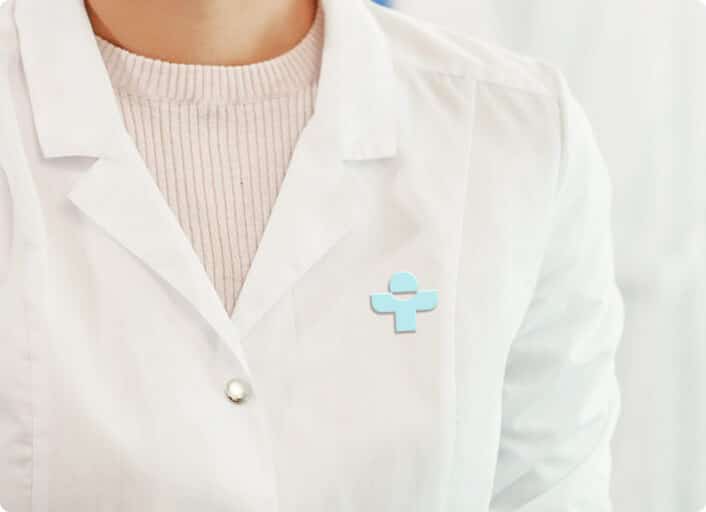 Closeup of a woman in a white coat with a Treated logo on it