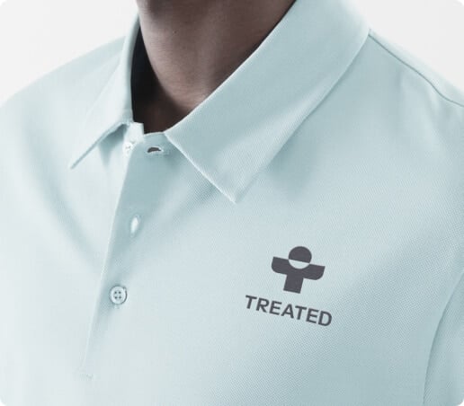 Closeup of a man in a pale blue polo shirt with a Treated logo on it
