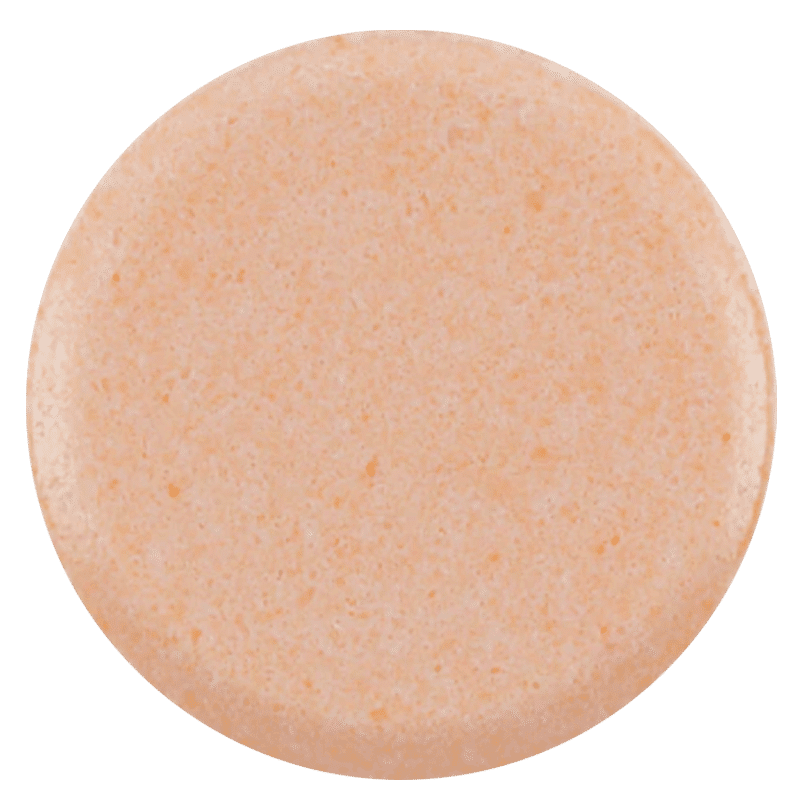 Close up of a salmon-coloured round tablet