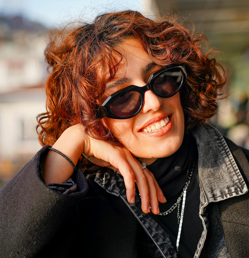 Woman in sunglasses resting head on hand